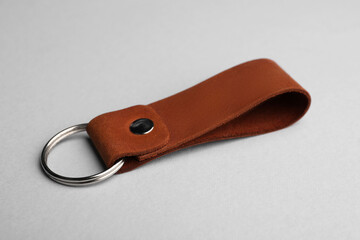 Leather keychain with Ukrainian coat of arms on light grey background, closeup