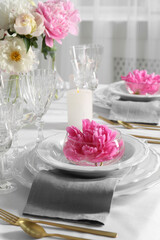 Stylish table setting with beautiful peonies in dining room