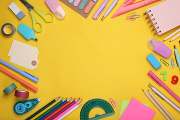 Back to school. Frame of different school stationery on yellow background, flat lay. Space for text