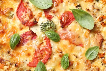 Tasty quiche with cheese, tomatoes and basil leaves as background, top view
