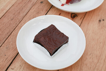 Chocolate brownies cake on white plate wooden table. homemade bakery and dessert. Bakery, confectionery concept