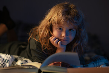 Child reading book. Little boy read books in living room watching pictures in story book. School...