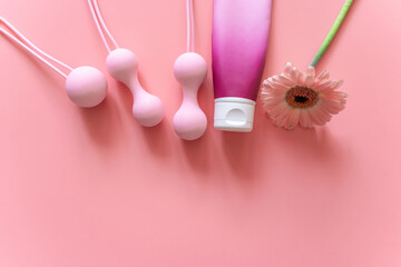Pink balls and lubricant for special exercises for woman. Balls for intimate muscles of women. Kegel balls for strenthening the pelvic floor muscles, vaginal muscles. Mock up. Close up