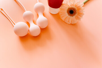 Pink balls and lubricant for special exercises for woman. Balls for intimate muscles of women. Kegel balls for strenthening the pelvic floor muscles, vaginal muscles. Mock up. Close up	