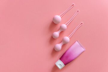 Pink balls and lubricant for special exercises for woman. Balls for intimate muscles of women. Kegel balls for strenthening the pelvic floor muscles, vaginal muscles. Mock up. Close up