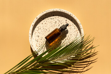 White tray and glass bottle with serum, vitamins with palm leaves and shadows on yellow background. Mock up. Close up. Skin care, wellness, self care, cosmetology concept 