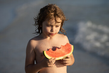 Child with watermelon on summer beach outdoor. Kid having fun in summer day. Kids summer vacation and healthy eating. Kittle kid eats juicy watermelon on the beach, coast, seashore. Summer fruits.