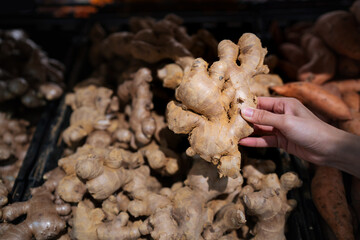 Lady hand select the ginger from the basket