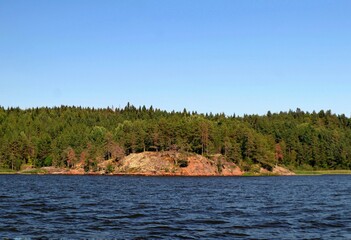 stone island overgrown with forest on Lake Ladoga in the Republic of Karelia