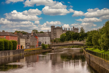 Classic view of Kilkenny castle from the river Nore with cloudy blue sky - obrazy, fototapety, plakaty
