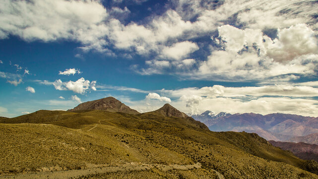 Cerros y monta&ntilde;as , angosto camino de tierra ( Ruta 13 ) degrades de colores a casi 4000 metros de altura , nubes q parecen de algod&oacute;n , y detr&aacute;s de la pre Cordillera , asoma el cerro Aconcagua , Mza