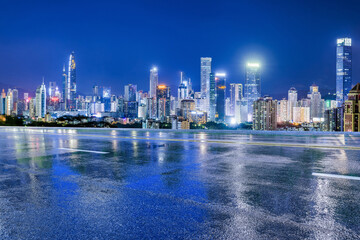 Asphalt highway and urban skyline with modern buildings at night in Shenzhen, Guangdong Province, China. Road and city buildings after the rain.
