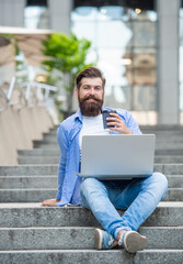 happy freelancer man has communication on pc outdoor. communication of freelancer man outside