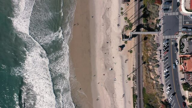 4K drone aerial tracking and stablishing shot of a beach with a pier in California