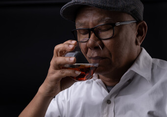 Asian senior man drinking whiskey on black screen