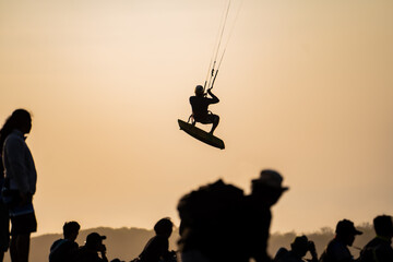 silhouettes of spectators and kitesurfers. A surfer in action. International Kitesurfing Exhibition 2023.