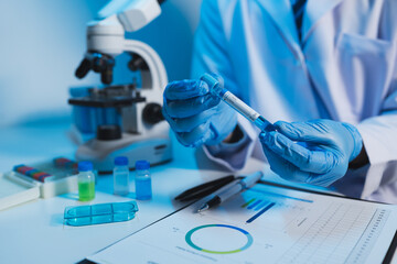 medical research laboratory Asian male scientist working using digital tablet analyze the sample record biochemical data medical science laboratory development of microbiology advanced equipment.