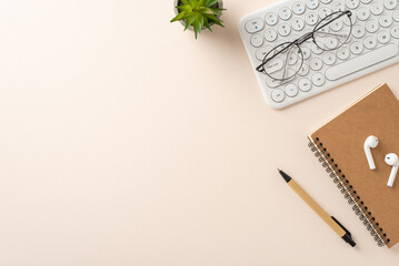 Professional workspace theme. Overhead shot of keyboard, notepad, pen, potted plant, glasses, earbuds on a soft backdrop. Ideal for text or ads