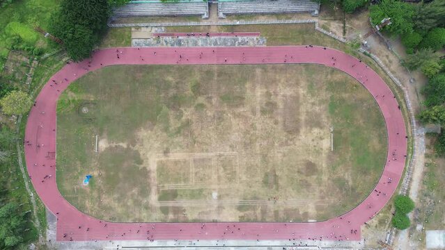 Aerial view of people running at the GOR Nani Wartabone, Gorontalo City. Group of people on the running track, the football field, or the soccer field. 