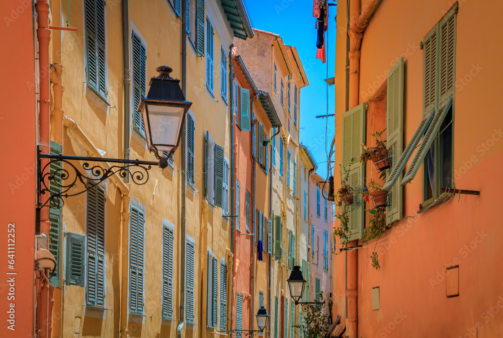 Poster picturesque old street light, colorful traditional houses with shutters in the background in the old