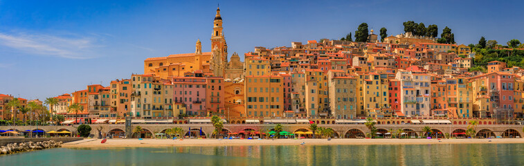 Colorful house facades above the Mediterranean Sea and beach in Old Town Vieille Ville of Menton on...