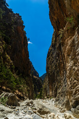 Towering vertical cliffs and a rocky, dry riverbed in the Samaria Gorge, Crete, Greece