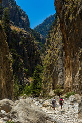 Hikers in a narrow, deep gorge on a hot summers day