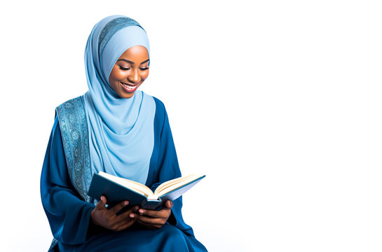 Muslim African woman wearing a hijab, reading a book. Could be the Quran. Isolated on a white background with copy space.