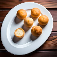 Cheese bread (Brazilian pao de queijo mineiro), top view, white background, on a heart shaped plate.AI generated