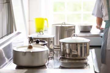 Metal pans in an industrial kitchen. Cooking on a professional stove.