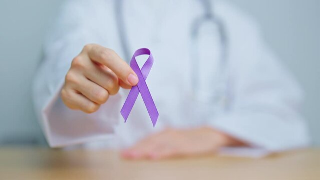 Doctor holding purple Ribbon for Violence, Pancreatic, Esophageal, Testicular cancer, Alzheimer, epilepsy, lupus, Sarcoidosis and Fibromyalgia. Awareness month and World cancer day concept