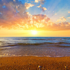 sandy sea beach at the dramatic sunset