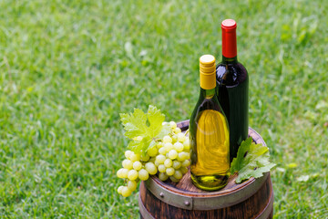 Fototapeta premium Wine bottles and grape on barrel