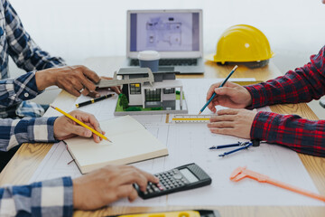 A team of engineers and architects are discussing or analyzing to build a housing project. Concept of construction contracts and agreements.