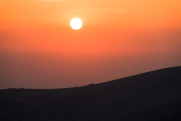 Fototapeta premium The sun sets on the mountain. Beautiful sunset in a mountainous area.