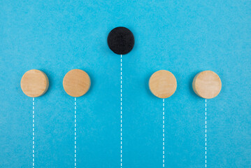Leadership concept, black wooden block on a blue background. Another, not like everyone else.