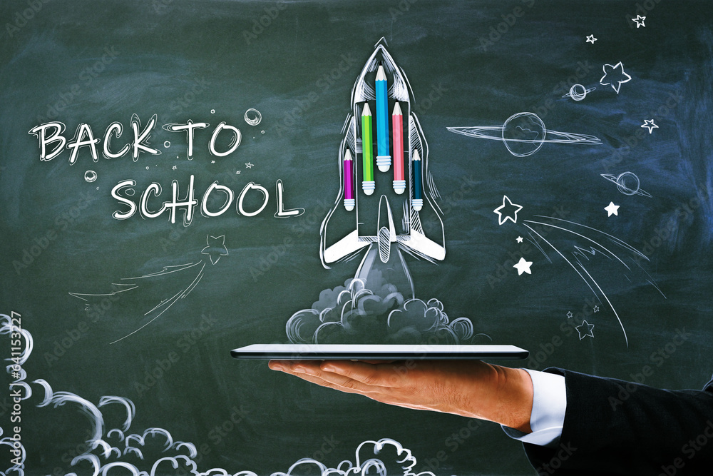 Poster close up of male hand holding tablet with abstract back to school sketch with pencils and rocket on 