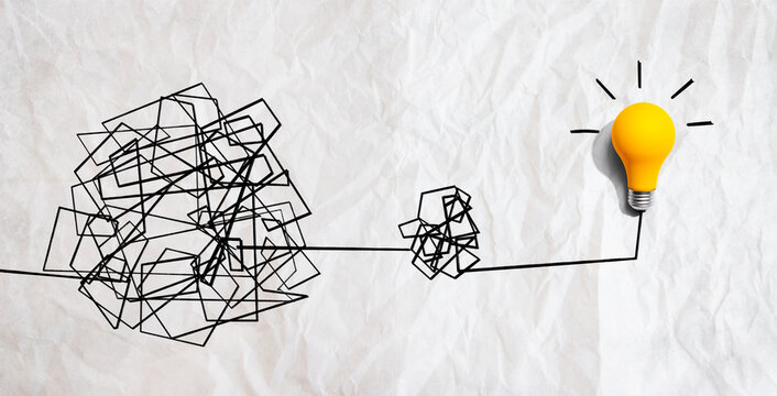 Clarifying complex ideas theme with light bulb - Flat lay