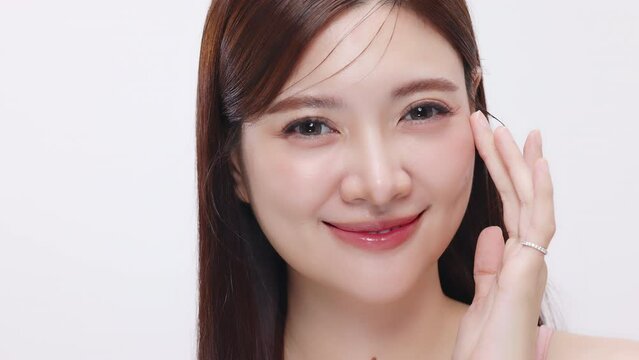 Slow motion shot Close up face of young beautiful Asian woman with k-beauty make up on isolated white background. Fresh and healthy facial skin commercial advertising look.