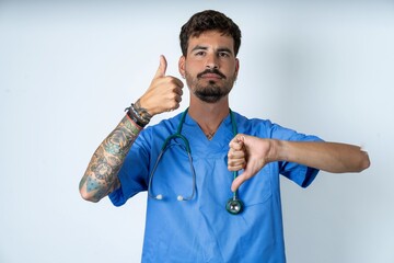 young caucasian doctor man wearing blue medical uniform showing thumbs up and thumbs down,...