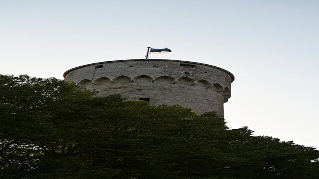 Tallinn, Estonia - August 29, 2023: Estonia flag on main Pikk Herman tower at summer night before sunset