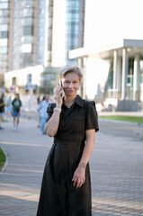 Business Woman With Phone Near Office. Portrait Of Beautiful senior Female In Fashion Office Clothes Talking On Phone While Standing Outdoors. Phone Communication.