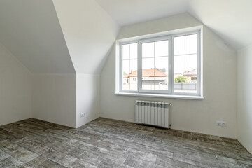 A room in a private house immediately after laying the floor, white unfinished walls and ceiling
