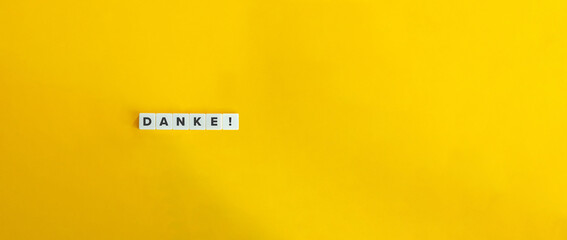 Danke Word and Inscription on Letter Tiles on Yellow Orange Background. Minimal aesthetic.