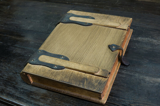 old log book in a wooden case with clasps on a black tabletop, closed