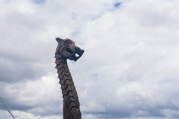 figurehead on the bow of a full-scale replica of a viking ship, against a sky - obrazy, fototapety, plakaty