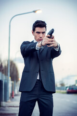 Photo of a man holding a firearm in a formal attire