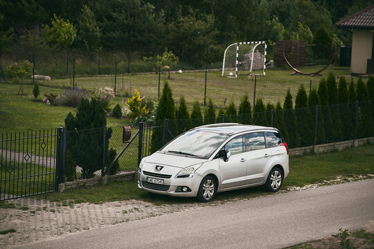 03.07.2023. Poland, Europe. Family French minivan parkside on the countryside road. Peugeot 5008  2009 - 2016 MPV on the street