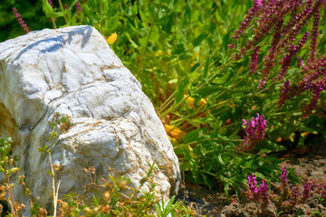White marble stone among flowers, element of design and landscaping