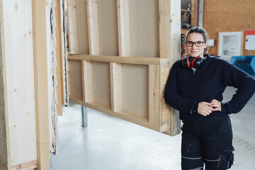 Female Carpenter Leaning Against a Wall She Built